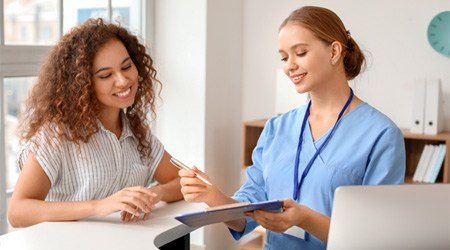 a dental assistant walking a patient through a cost estimate