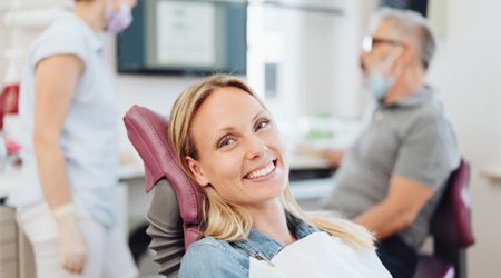 Happy female dental patient in treatment chair