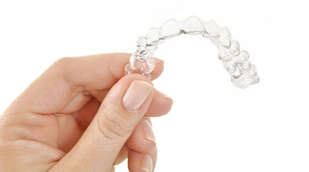 Closeup of patient holding clear aligner