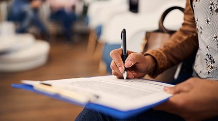 Woman filling out dental insurance form in lobby